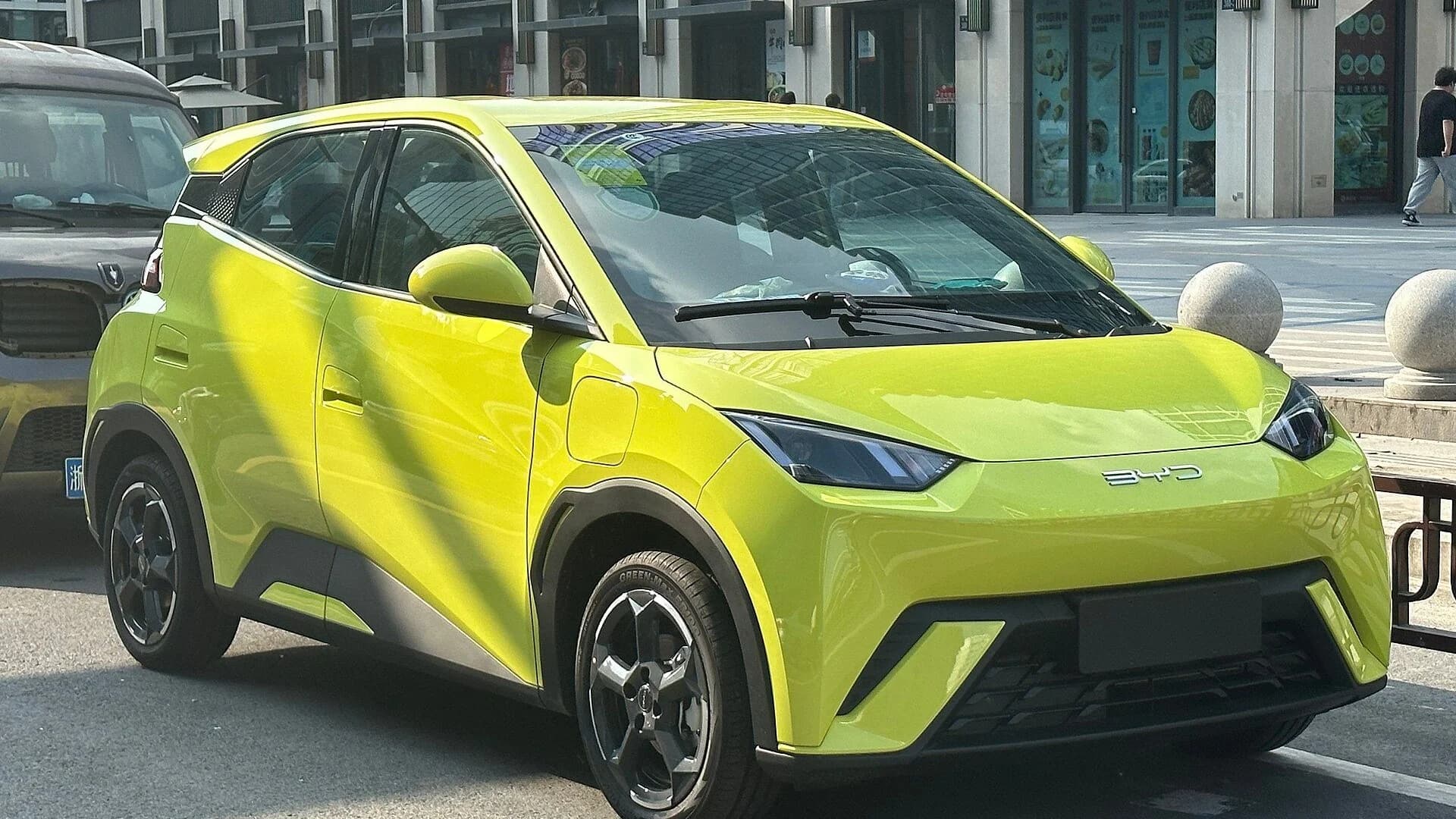 A lime green BYD Seagull electric hatchback parked outdoors on an urban street.