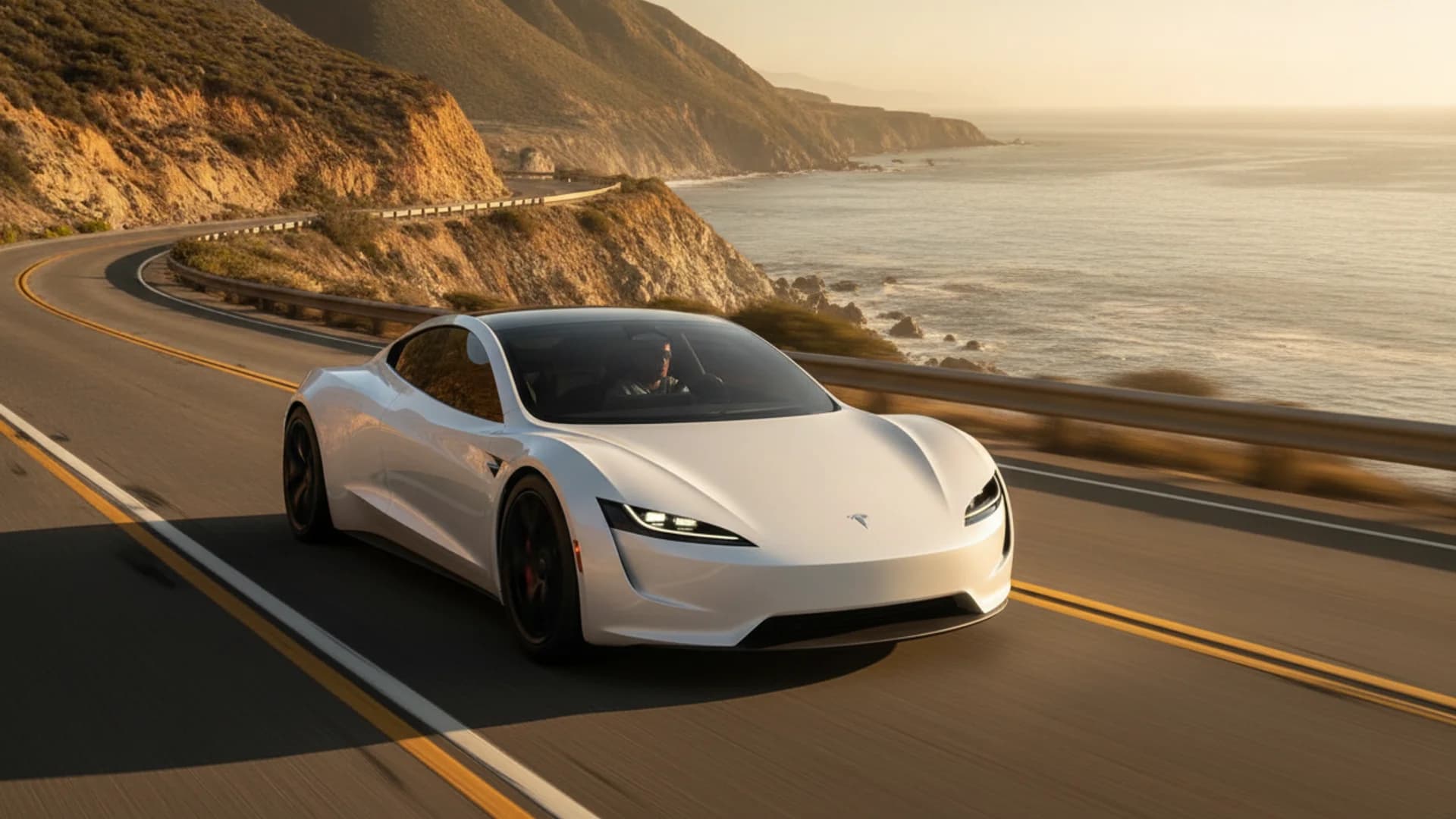 The next-generation Tesla Roadster on a coastal highway at golden hour