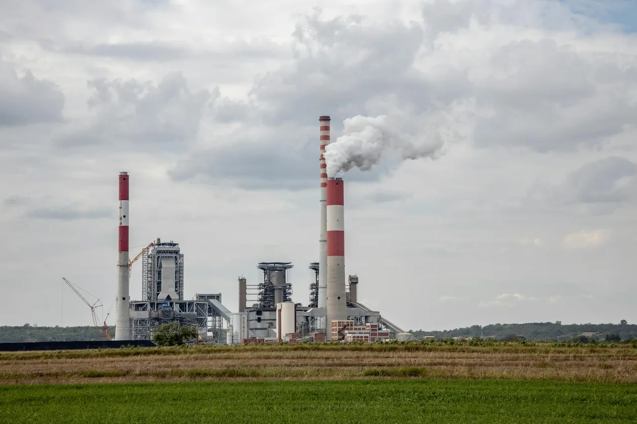 Coal-fired power plant with smokestacks illustrating grid electricity sources for EV charging and emissions comparisons