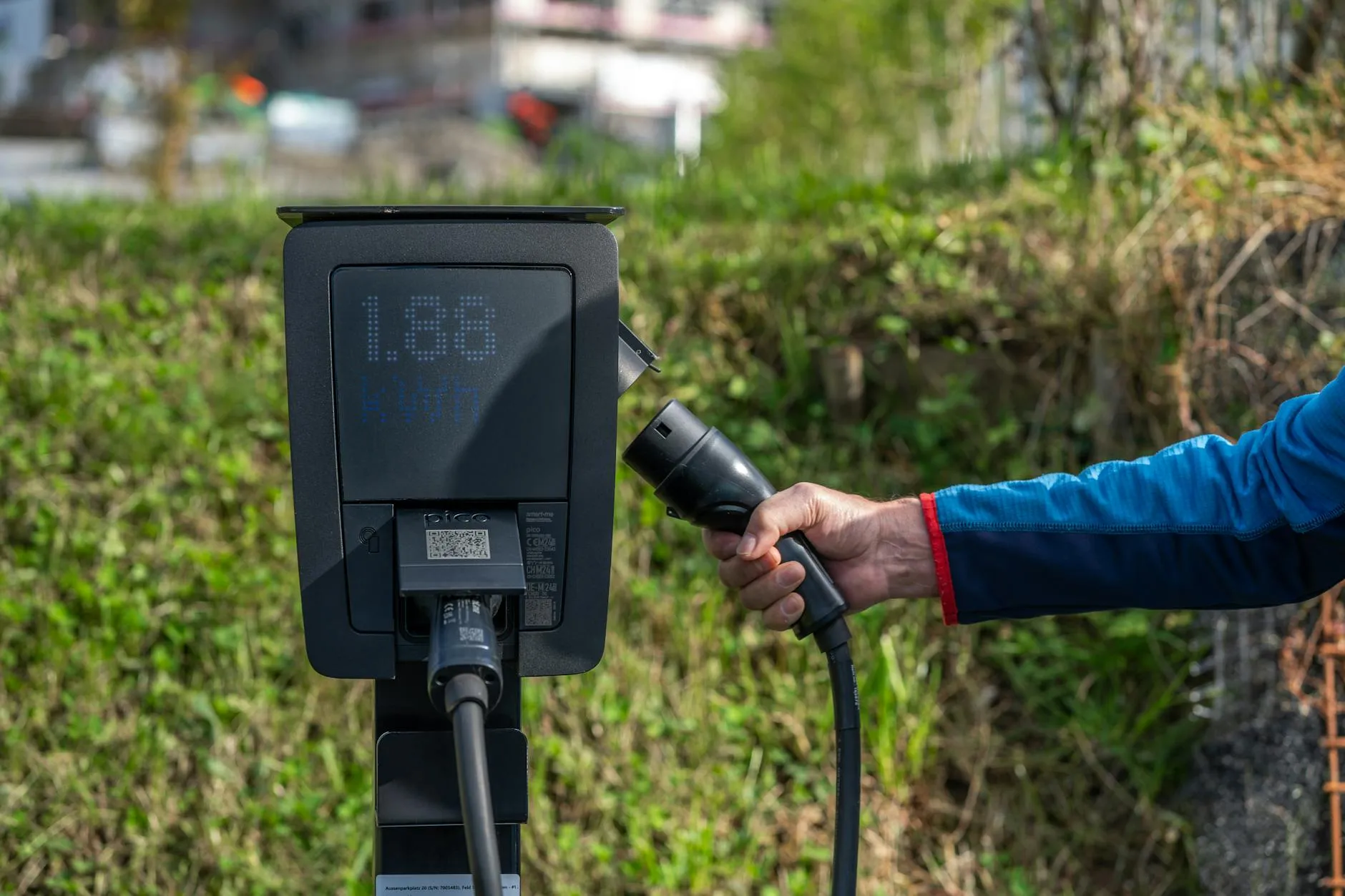 Red electric car parked outdoors, showcasing sleek design amidst winter scenery.