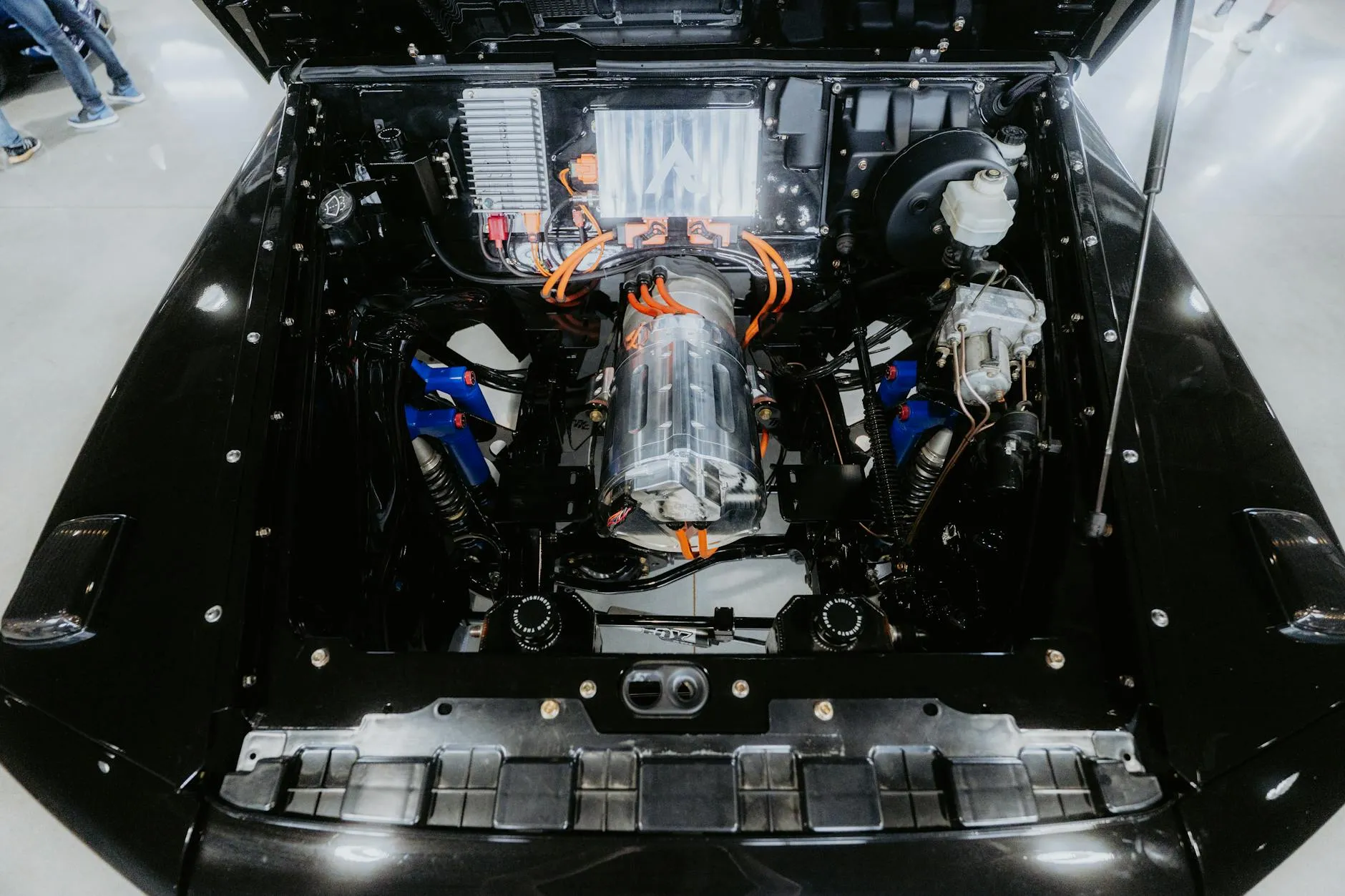 Close-up of a person plugging in an electric car at a charging station outdoors.