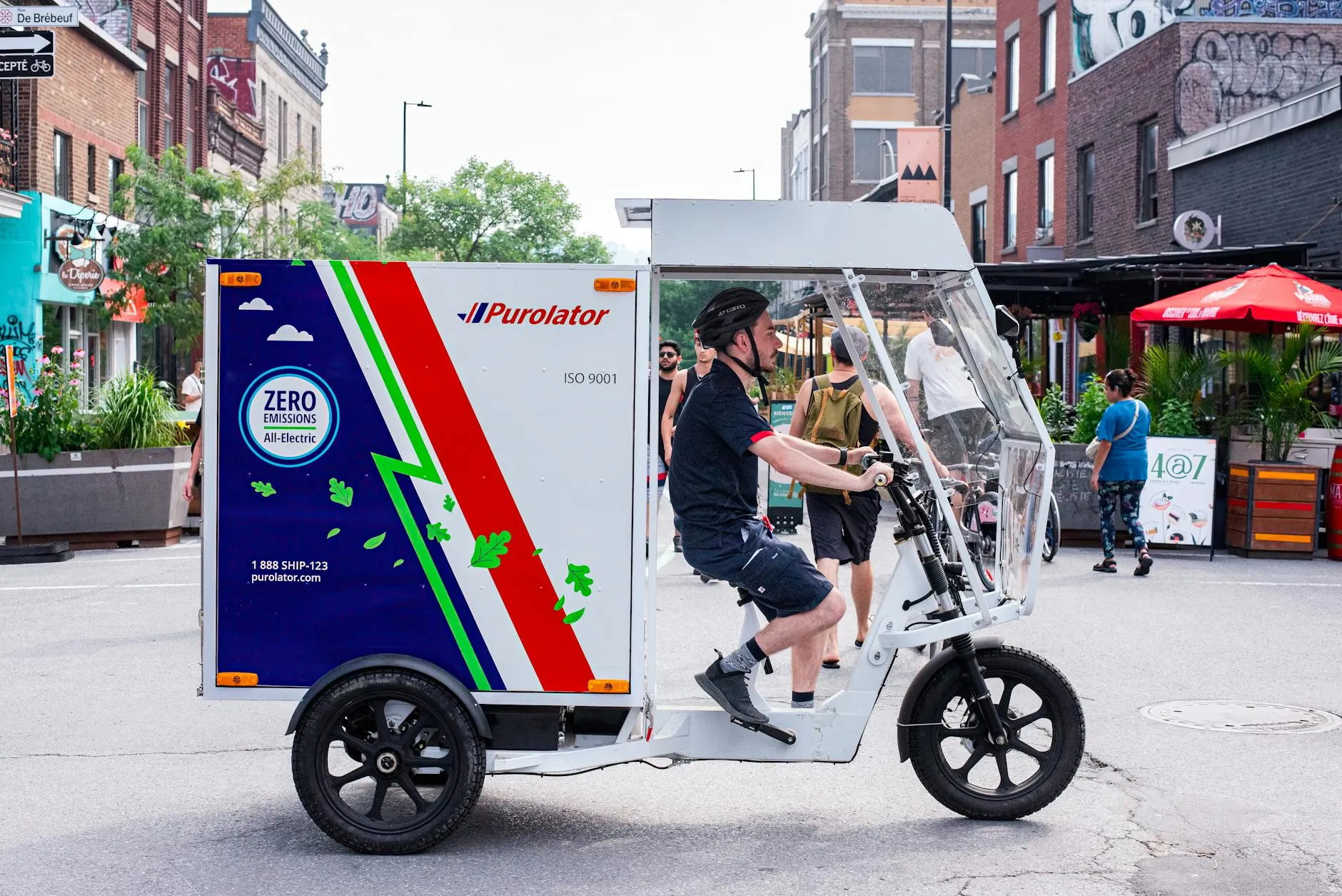 Close-up of a person plugging in an electric car at a charging station outdoors.