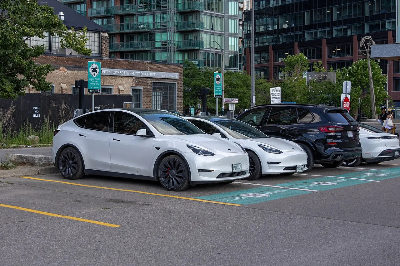 Canadian EV drivers at a public charging station surrounded by mountains showing community charging etiquette
