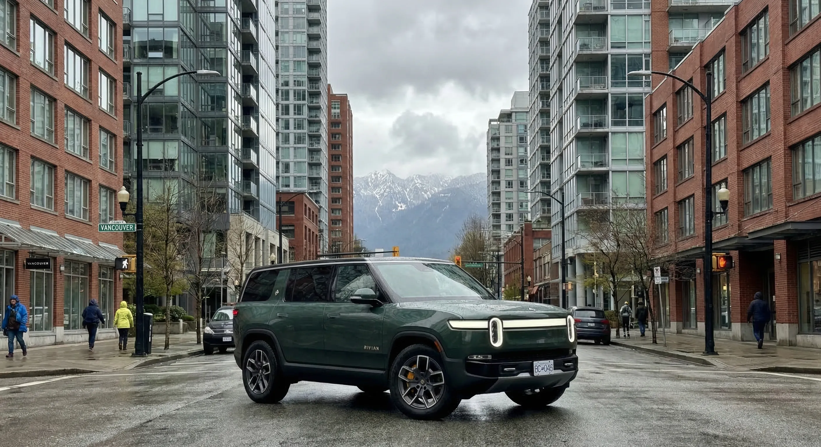 Rivian R2 compact electric SUV on Canadian city street with mountains in background — ThinkEV Canada preview