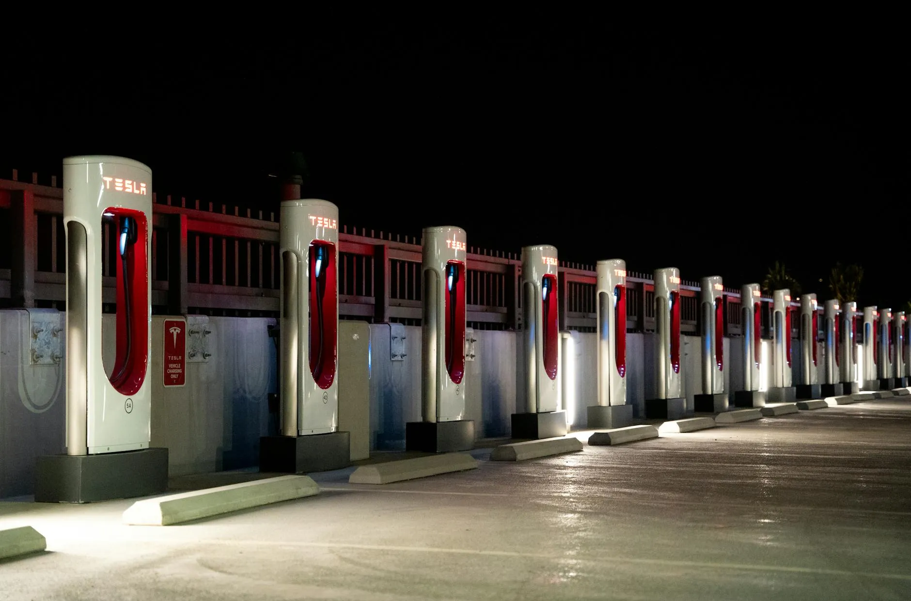 Tesla Supercharger station with multiple vehicles charging in an urban corridor, illustrating congestion at high-density Supercharger nodes